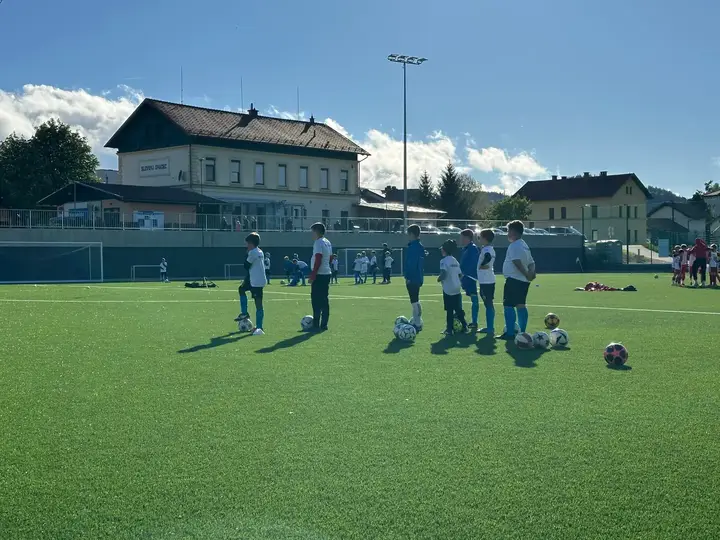 Mladi igralci z žogami na novem igrišču z umetno travo